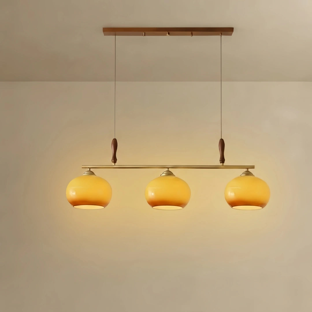 Moderne Pendelleuchte – Bernsteinfarbene Glasschirme & Messingstange mit Holz-Akzent für Esstisch