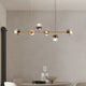 Modern chandelier for dining ambiance featuring stylish glass globes and a sleek gold frame.