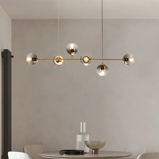 Modern chandelier for dining ambiance featuring stylish glass globes and a sleek gold frame.