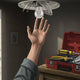 Person reaching for a light bulb while holding tools, illustrating light troubleshooting steps.