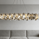 Stunning crystal chandelier above a modern gray sofa in an elegant living room, showcasing styles in the buyer's guide to crystal chandeliers.