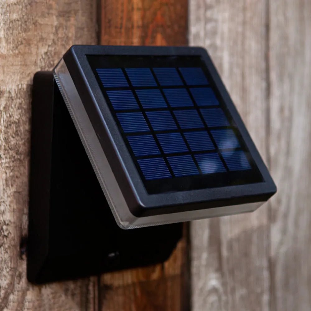 Outdoor solar lights benefits illustrated by a close-up of a solar panel on a wooden wall.