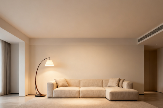 A cozy living room featuring modern lighting design aesthetics with a stylish arched floor lamp and a plush sofa.