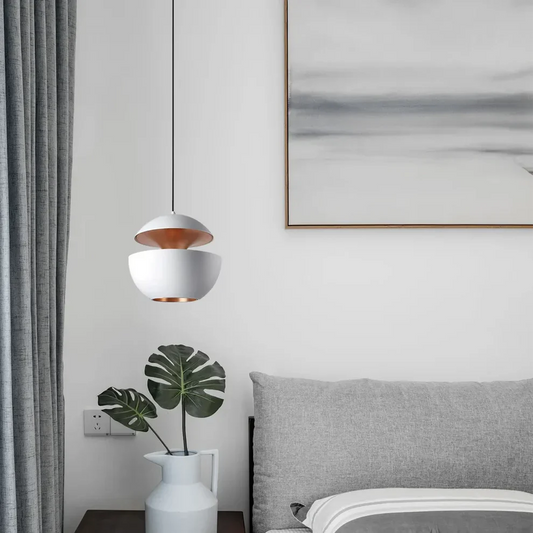 Modern pendant light above bedside table in a stylish bedroom, showcasing the best modern pendant light for bedroom.