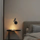 Trendy wall lamps for contemporary homes illuminating a bedside table in a modern bedroom setting.