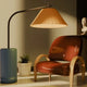 A stylish modern floor lamp beside a unique chair in a cozy interior, showcasing the best modern floor lamps 2025.